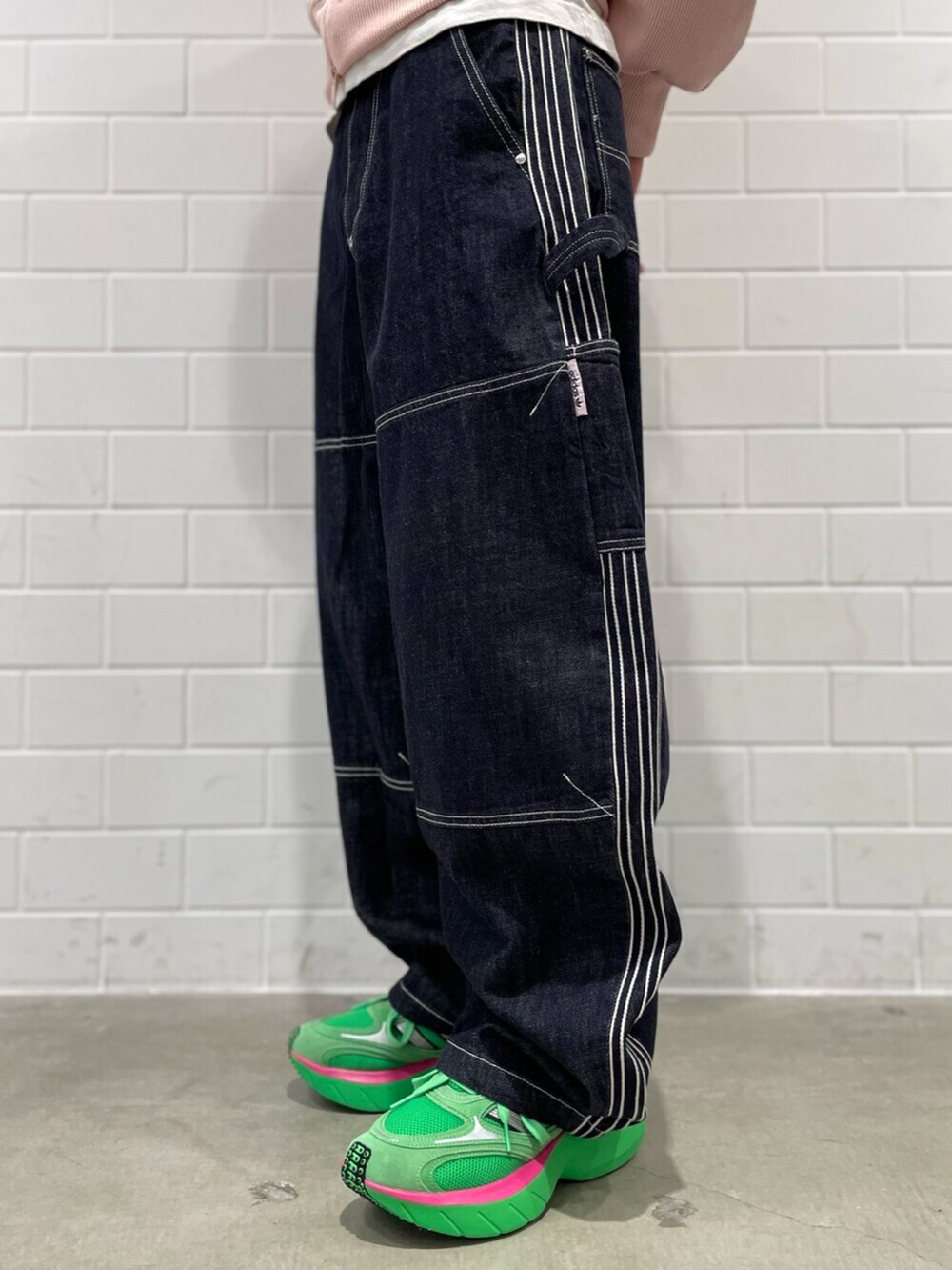 ブルー系のデニムパンツ、ピンク系のトップス、グリーン系のシューズを着用したメンズの冬コーディネートの5枚目の写真