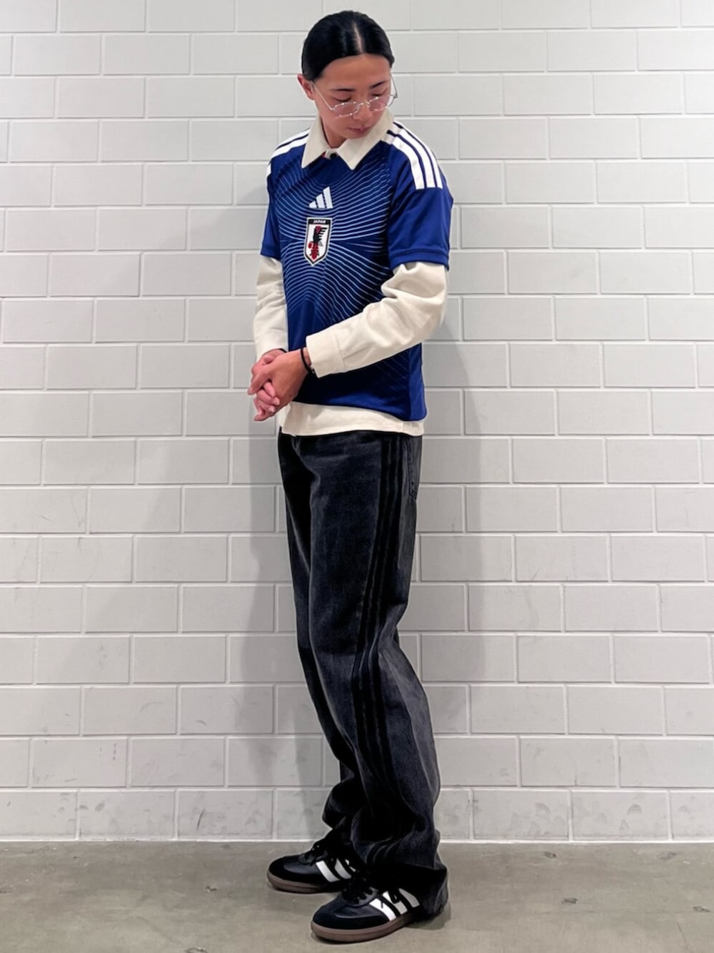 ブラック系のデニムパンツ、ブルー系のTシャツ/カットソー、ブラック系のスニーカーを着用したメンズの秋コーディネートの3枚目の写真