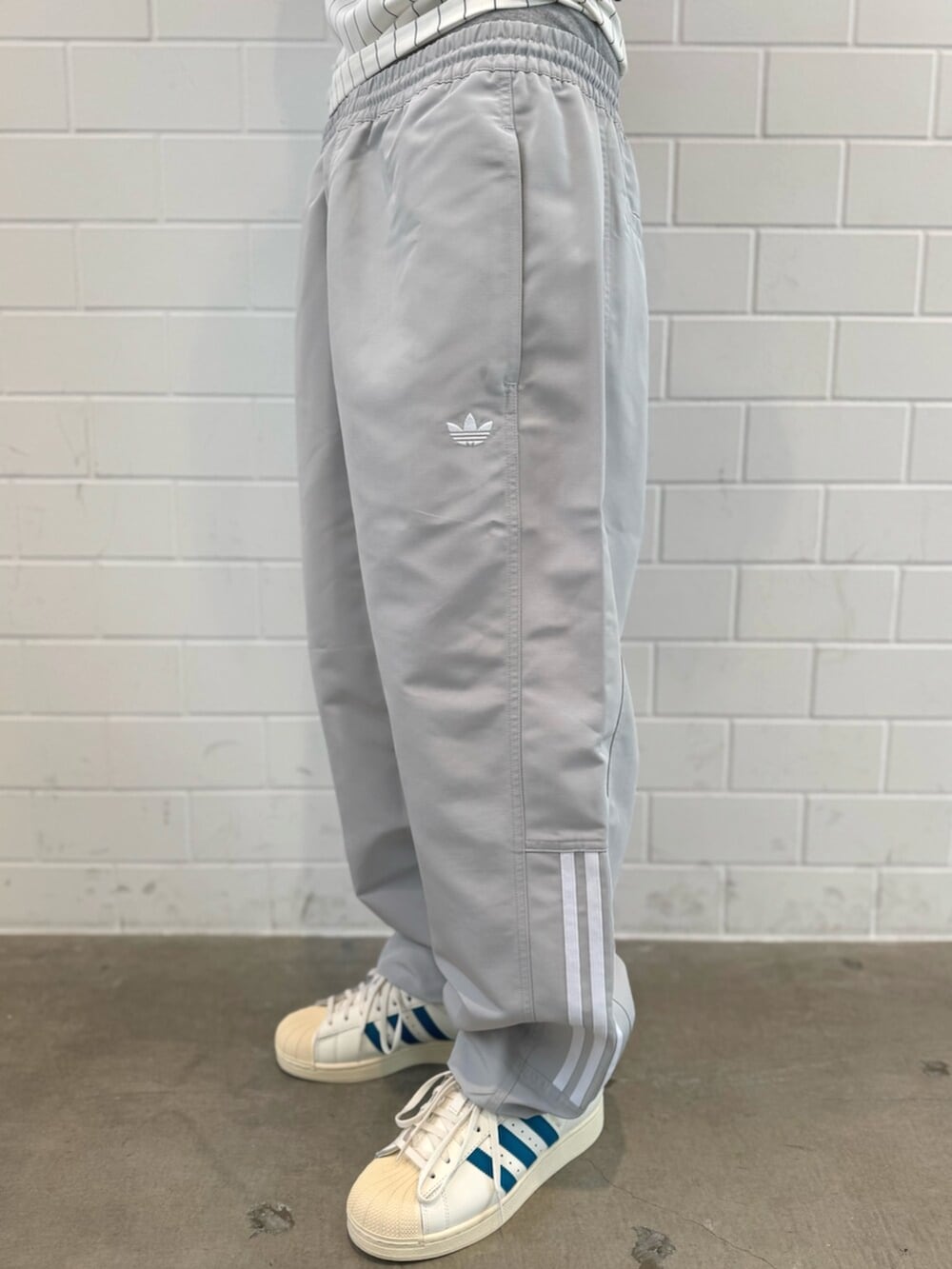 ホワイト系のTシャツ/カットソー、ホワイト系のスニーカー、ブラック系のニットキャップ/ビーニーを着用したメンズの秋コーディネートの5枚目の写真