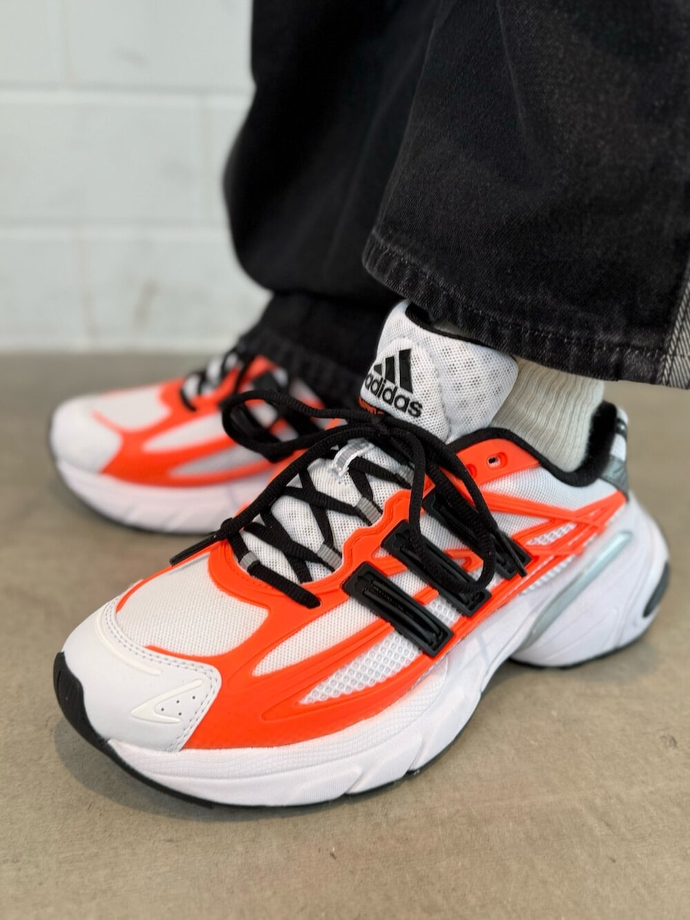 グレー系のニット/セーター、ブラック系のデニムパンツ、ホワイト系のスニーカーを着用したメンズの冬コーディネートの6枚目の写真