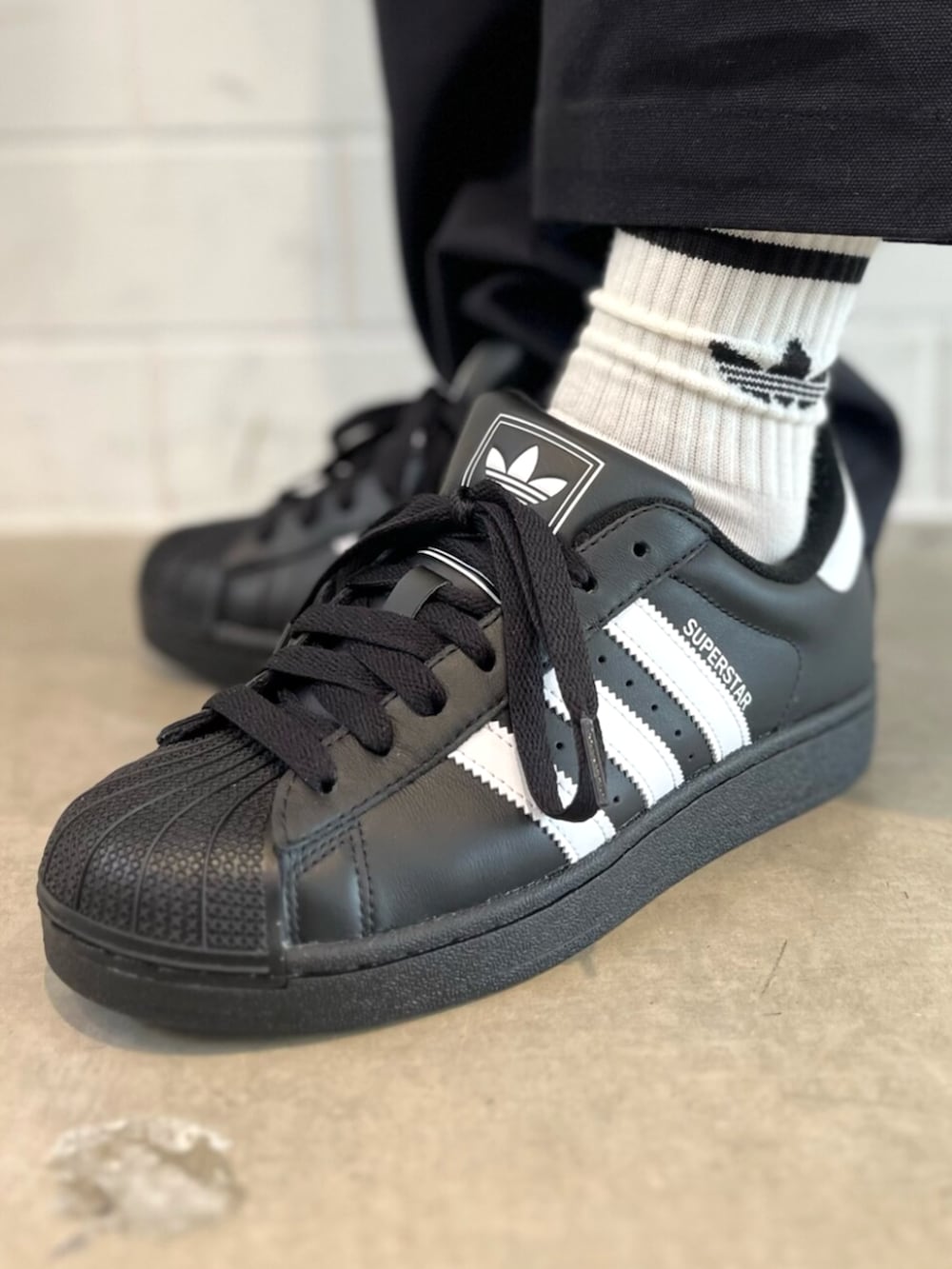 ブラック系のブルゾン、ブラック系のスニーカーを着用したメンズの秋コーディネートの6枚目の写真