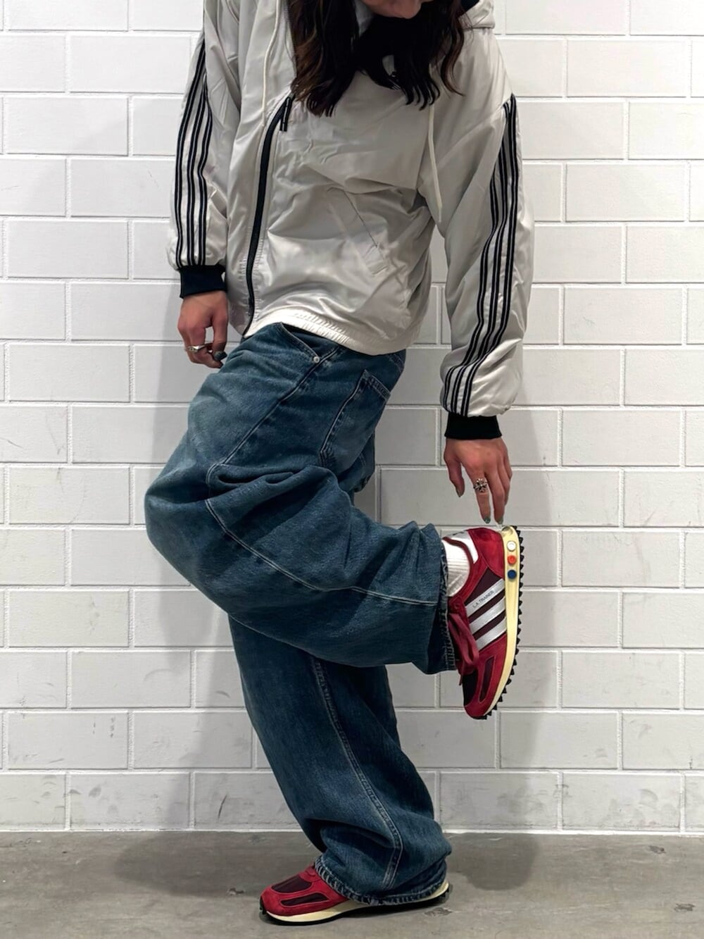 ベージュ系のブルゾン、レッド系のシューズ、ブルー系のニットキャップ/ビーニーを着用したメンズの秋コーディネートの2枚目の写真