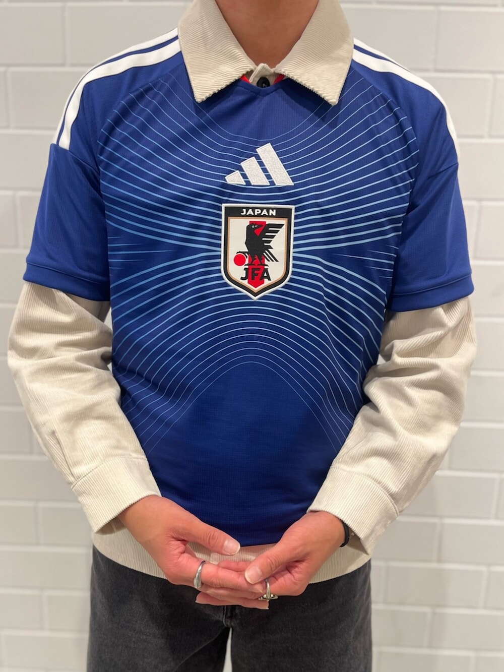 ブラック系のデニムパンツ、ブルー系のTシャツ/カットソー、ブラック系のスニーカーを着用したメンズの秋コーディネートの4枚目の写真