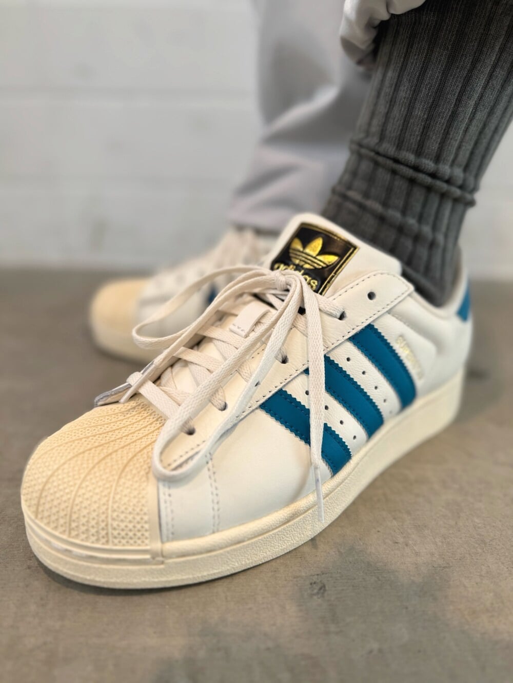 ホワイト系のTシャツ/カットソー、ホワイト系のスニーカー、ブラック系のニットキャップ/ビーニーを着用したメンズの秋コーディネートの6枚目の写真