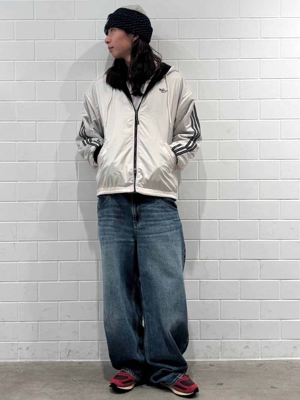 ベージュ系のブルゾン、レッド系のシューズ、ブルー系のニットキャップ/ビーニーを着用したメンズの秋コーディネートの3枚目の写真