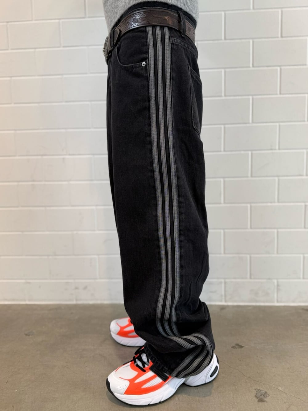 グレー系のニット/セーター、ブラック系のデニムパンツ、ホワイト系のスニーカーを着用したメンズの冬コーディネートの5枚目の写真