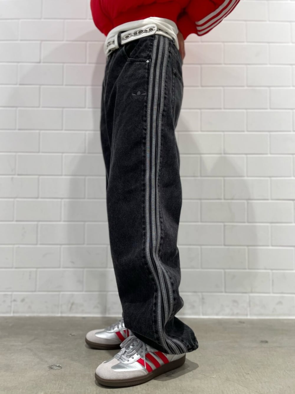 ブラック系のデニムパンツ、シルバー系のシューズ、レッド系のダウンジャケット/コートを着用したメンズの秋コーディネートの5枚目の写真