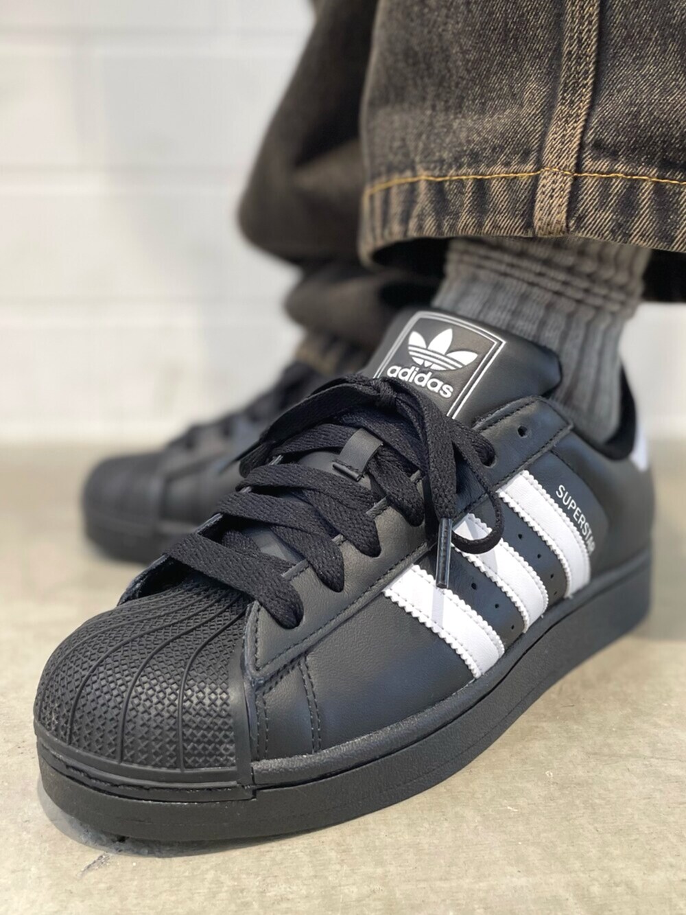 ブラック系のスニーカー、ブラック系のブルゾン、ブラウン系のデニムパンツを着用したメンズの冬コーディネートの6枚目の写真