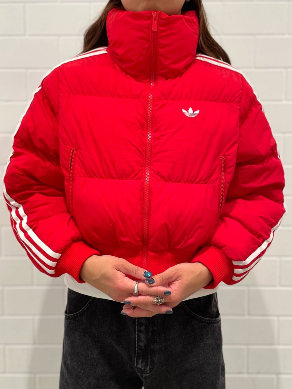 ブラック系のデニムパンツ、シルバー系のシューズ、レッド系のダウンジャケット/コートを着用したメンズの秋コーディネートの4枚目の写真