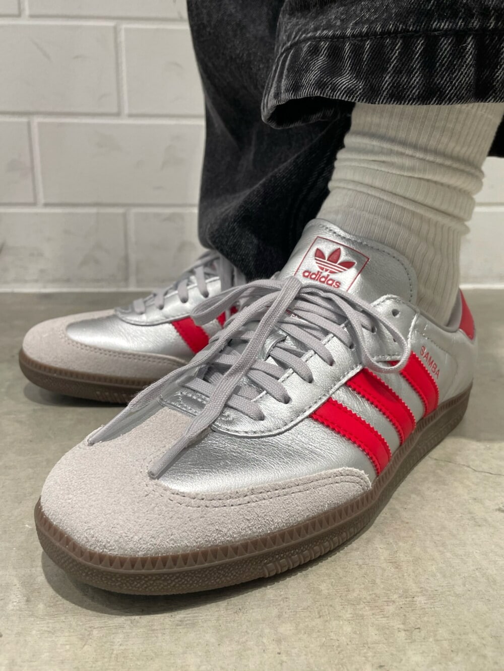 ブラック系のデニムパンツ、シルバー系のシューズ、レッド系のダウンジャケット/コートを着用したメンズの秋コーディネートの6枚目の写真