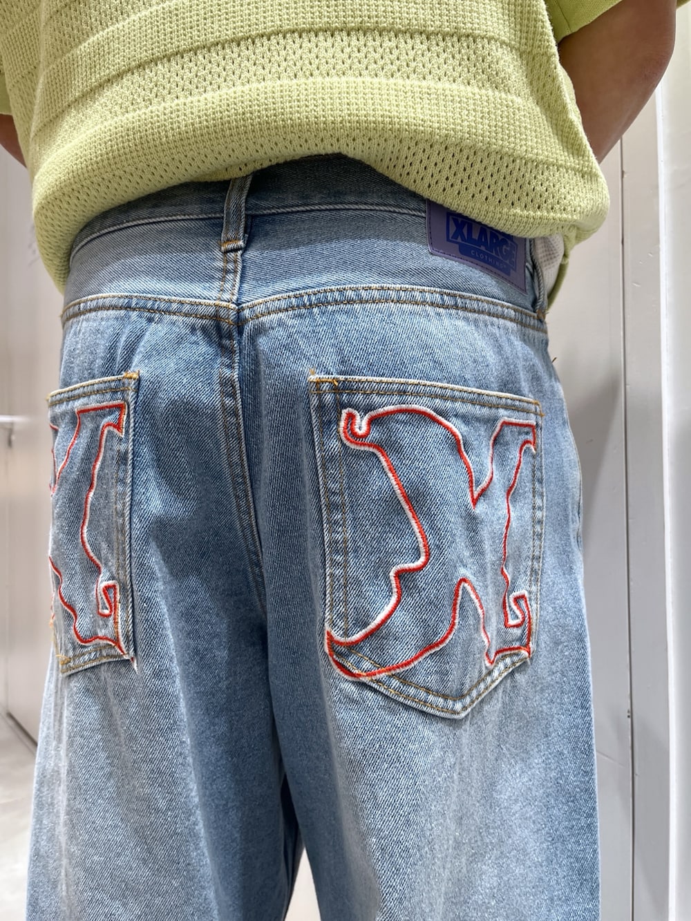 グリーン系のポロシャツ、ブルー系のデニムパンツ、ブラック系のバックパック/リュックを着用したメンズの夏コーディネートの7枚目の写真