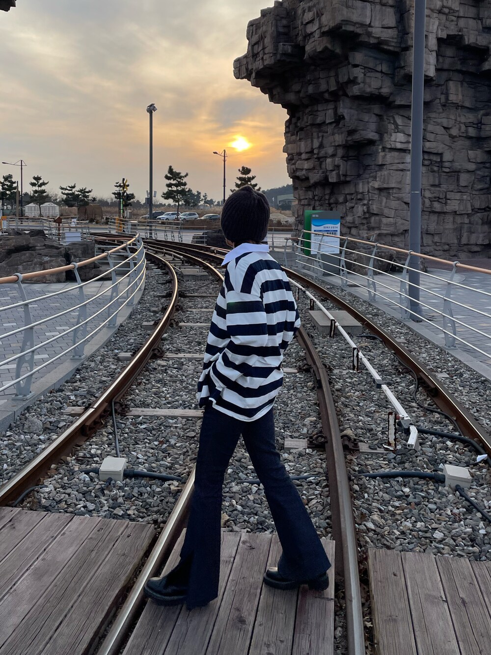 ブルー系のデニムパンツ、ブラック系のブーツ、グレー系のニットキャップ/ビーニーを着用したレディースの秋コーディネートの3枚目の写真