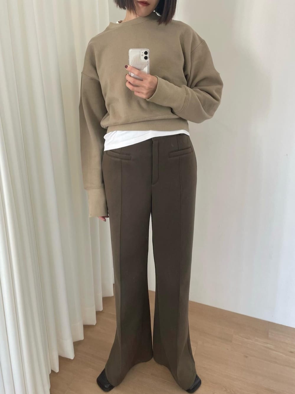 グリーン系のスウェット、グリーン系のスラックス、ブラック系のローファーを着用したレディースの秋コーディネートの3枚目の写真