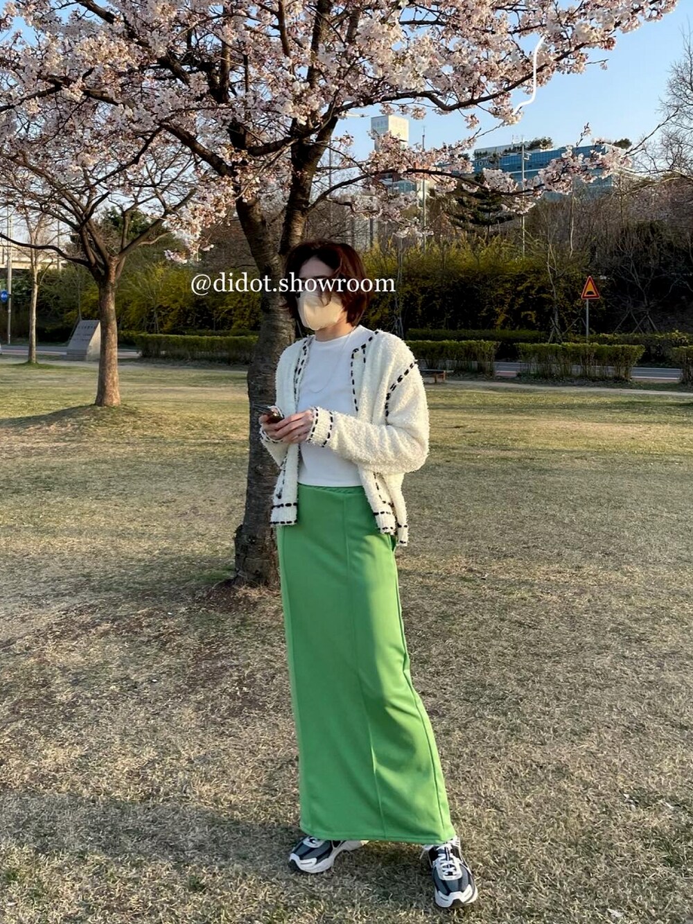 グリーン系のスカートを着用したレディースの春コーディネートの2枚目の写真