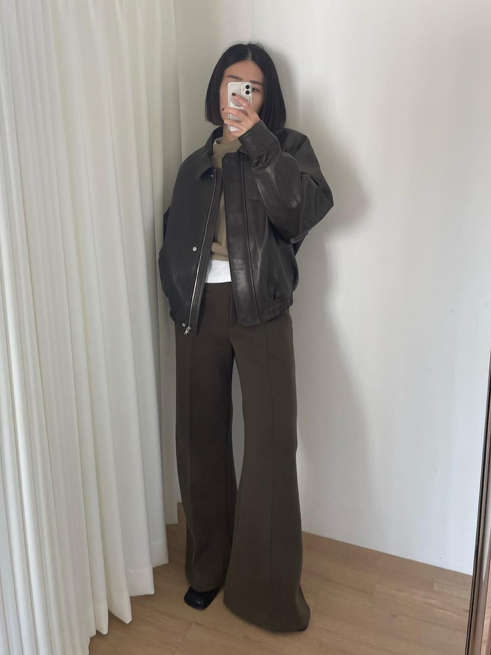 グリーン系のスウェット、グリーン系のスラックス、ブラック系のローファーを着用したレディースの秋コーディネートの2枚目の写真