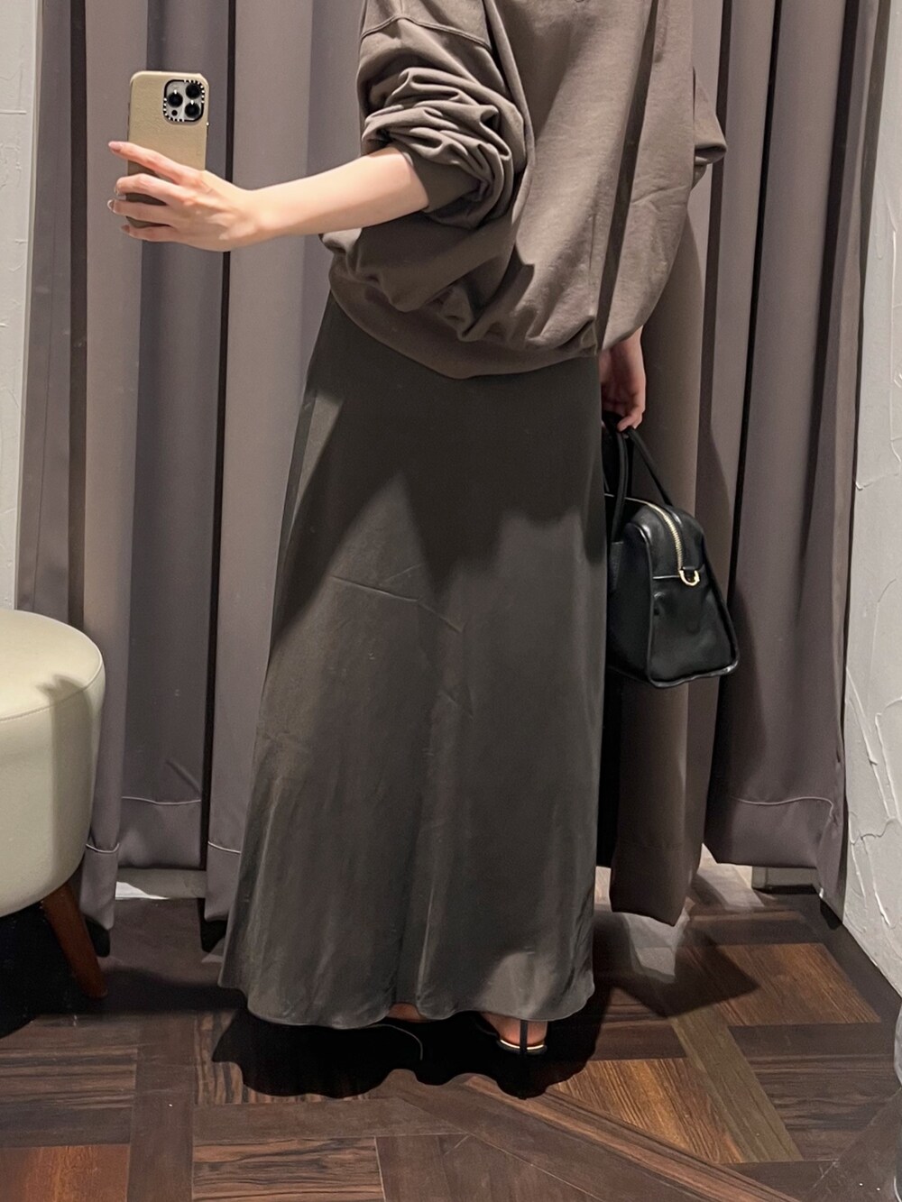 ブラウン系のスカート、ブラック系のボストンバッグ、ブラック系のパンプスを着用したレディースの冬コーディネートの9枚目の写真