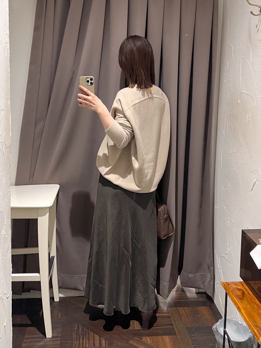 ベージュ系のニット/セーター、ブラウン系のスカート、ブラウン系のボストンバッグを着用したレディースの秋コーディネートの4枚目の写真
