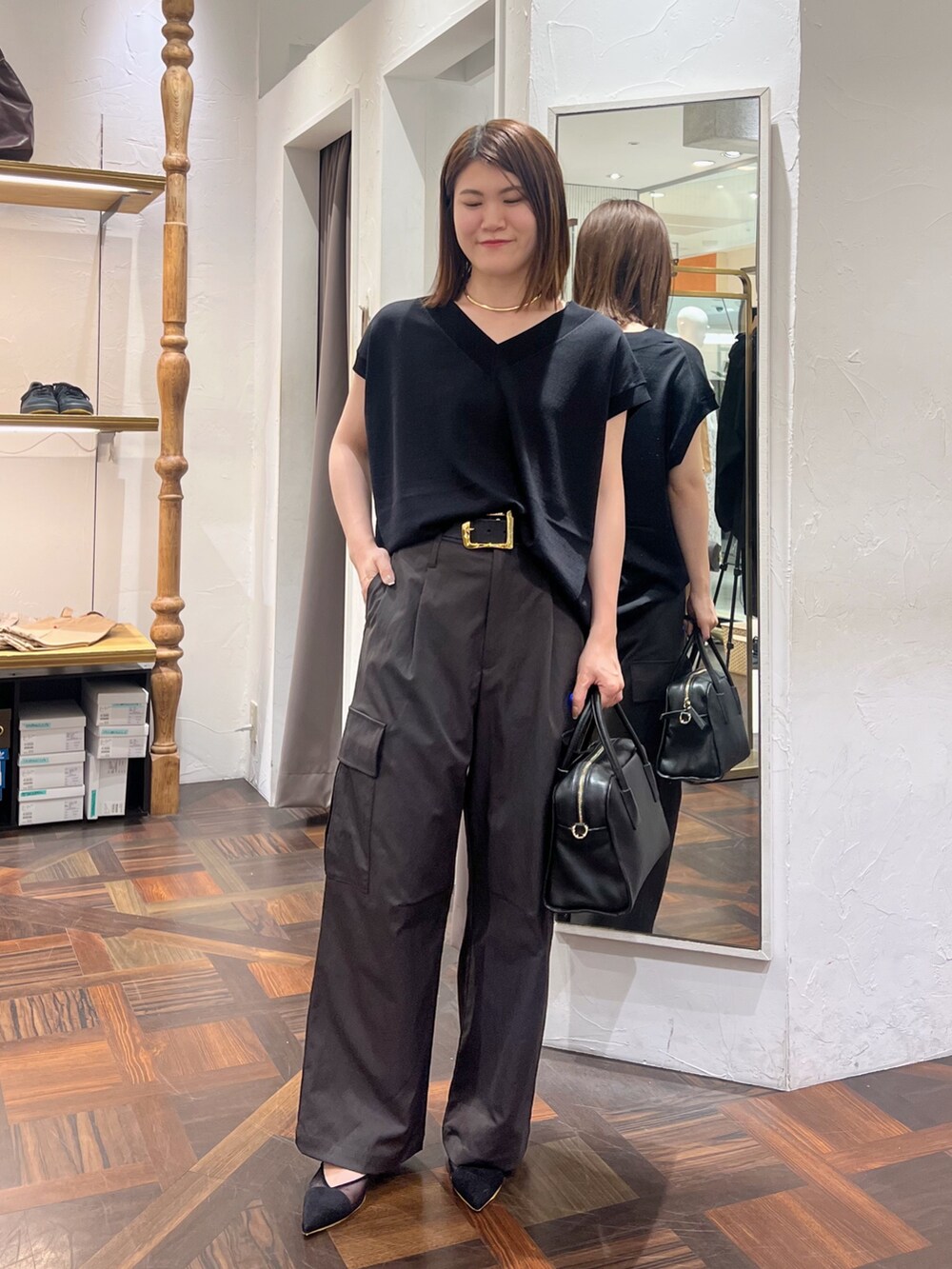 ブラック系のニット/セーター、ブラック系のボストンバッグ、ブラック系のパンプスを着用したレディースの秋コーディネートの2枚目の写真