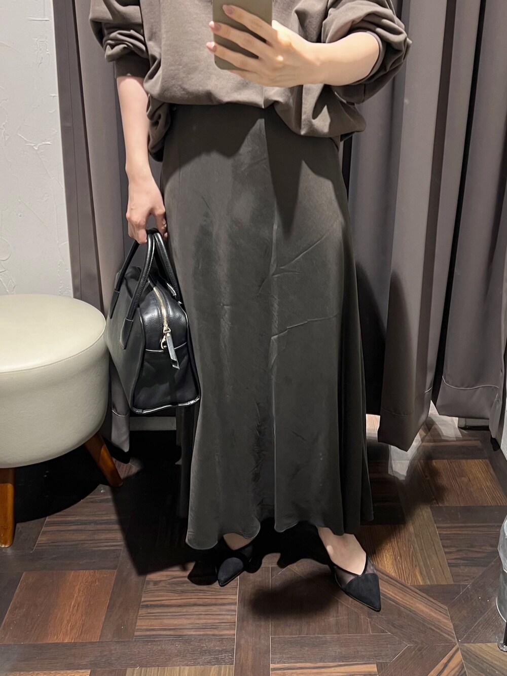 ブラウン系のスカート、ブラック系のボストンバッグ、ブラック系のパンプスを着用したレディースの冬コーディネートの7枚目の写真