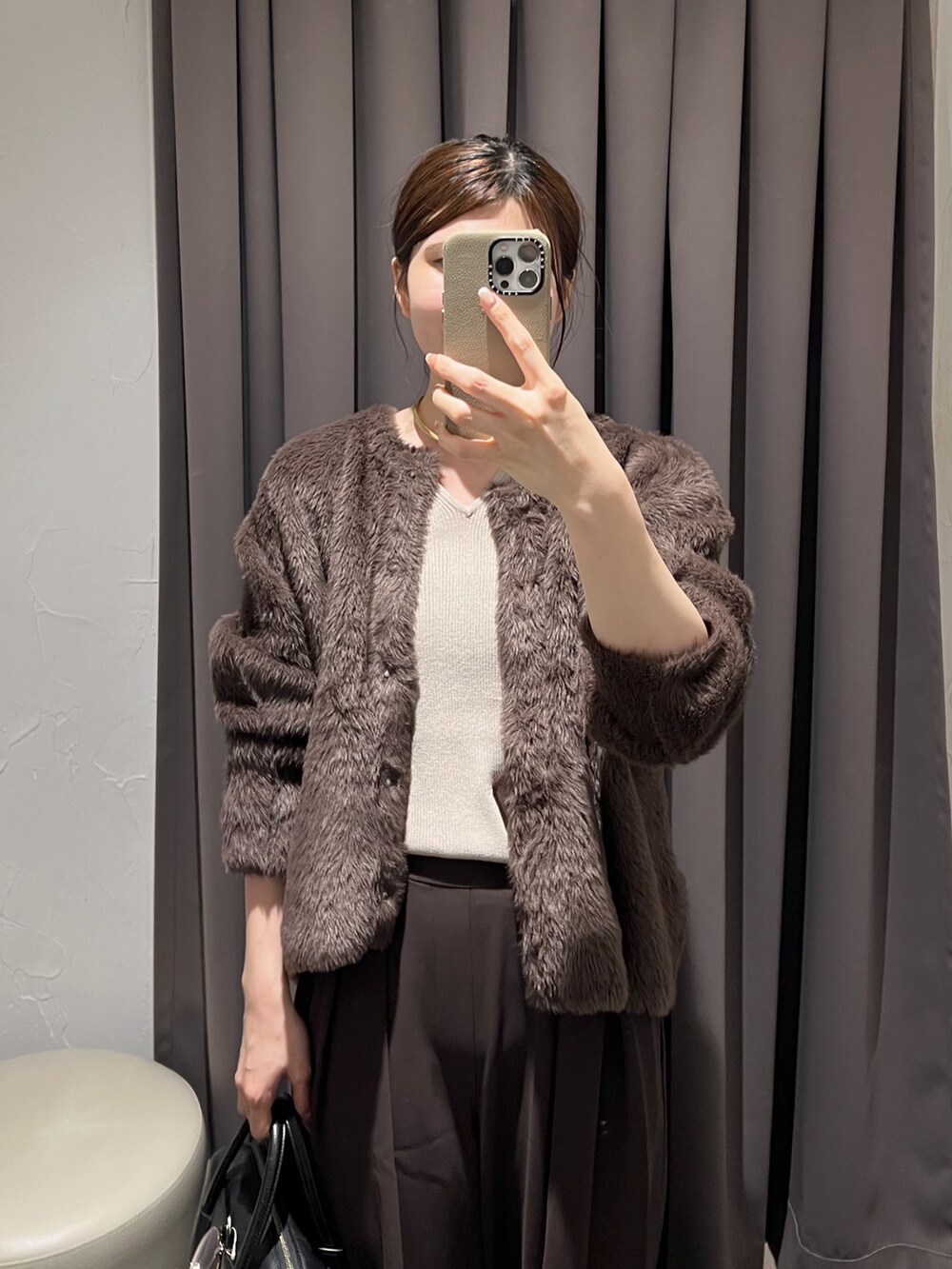 ブラウン系のカーディガン/ボレロ、ブラウン系のスラックス、ブラック系のパンプスを着用したレディースの冬コーディネートの5枚目の写真