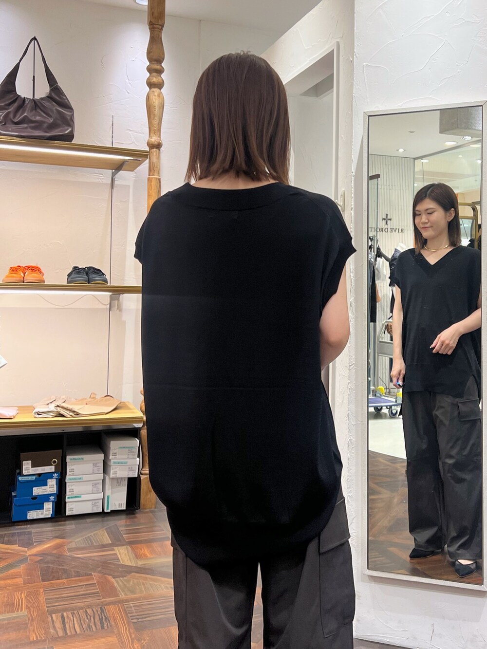 ブラック系のニット/セーター、ブラック系のボストンバッグ、ブラック系のパンプスを着用したレディースの秋コーディネートの7枚目の写真