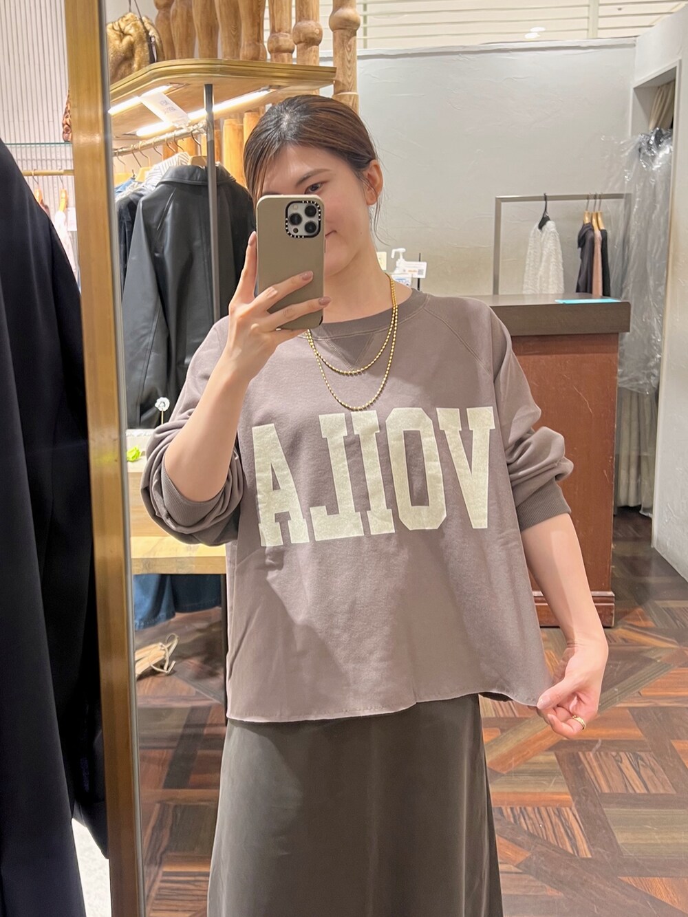 ブラウン系のスウェット、ブラウン系のスカート、ブラウン系のショルダーバッグを着用したレディースの秋コーディネートの8枚目の写真