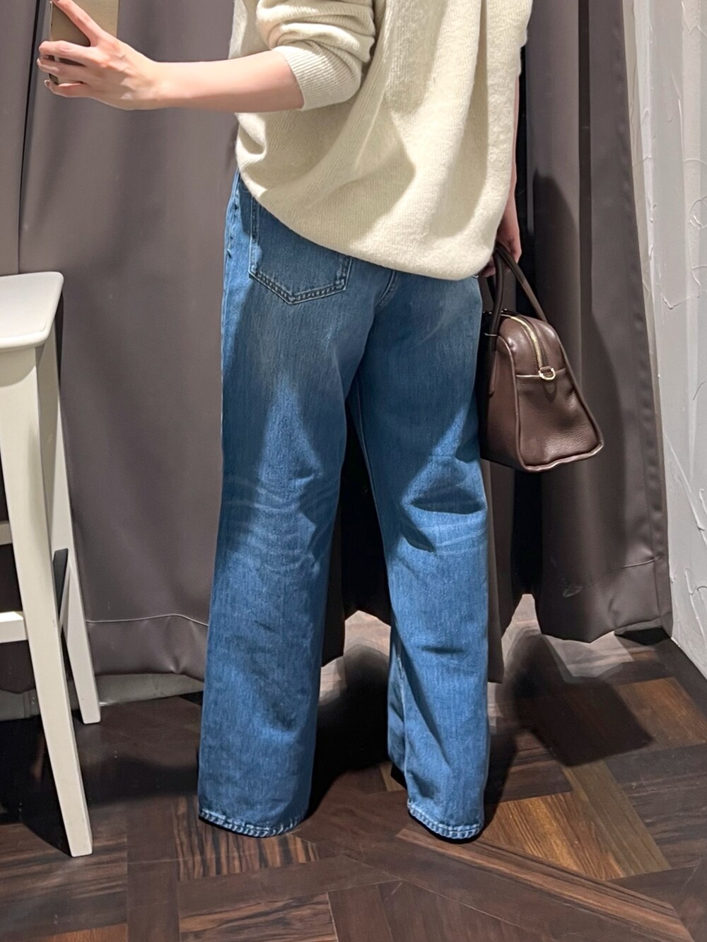 ベージュ系のニット/セーター、ブルー系のデニムパンツ、ブラウン系のボストンバッグを着用したレディースの秋コーディネートの10枚目の写真