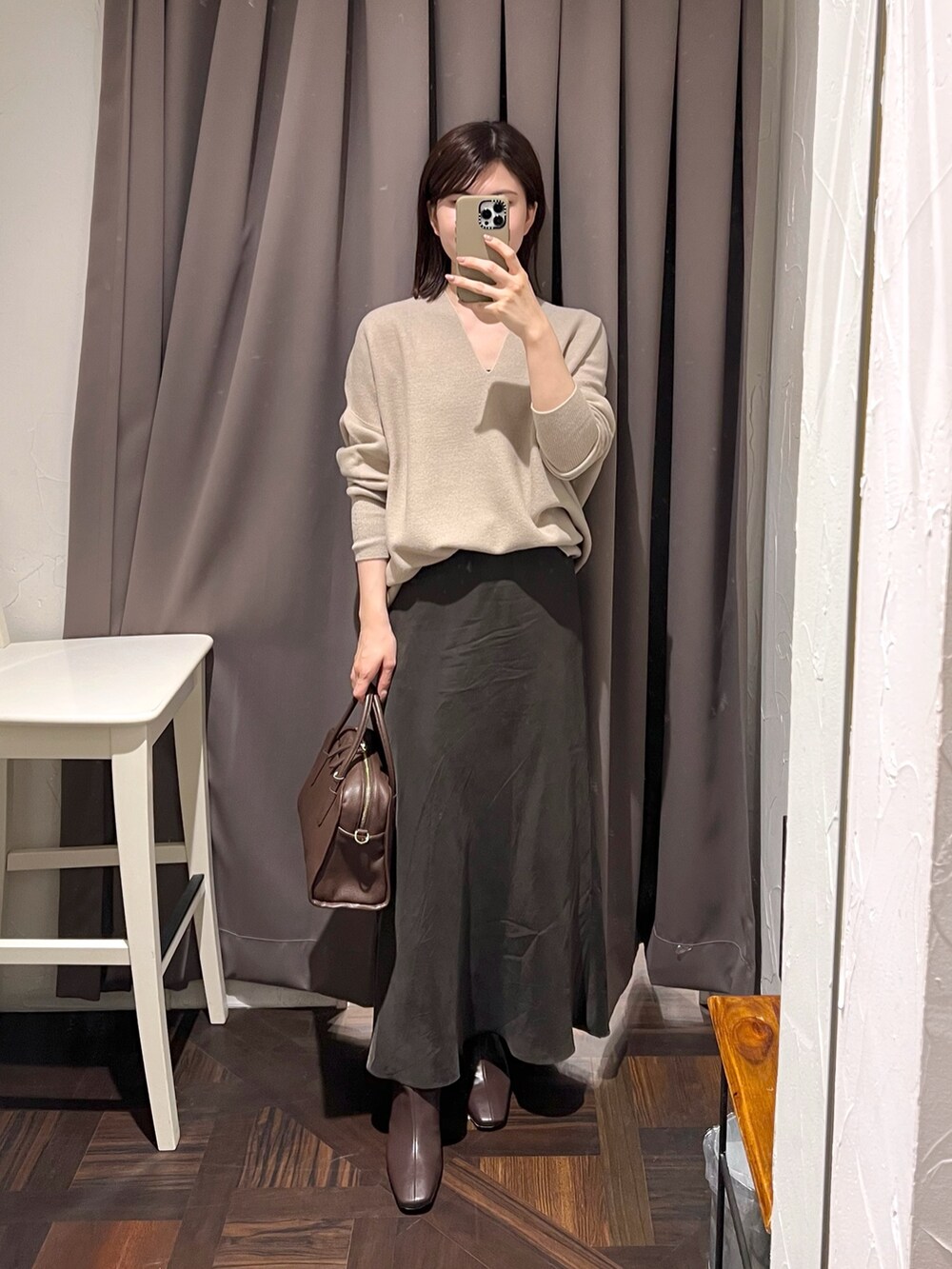 ベージュ系のニット/セーター、ブラウン系のスカート、ブラウン系のボストンバッグを着用したレディースの秋コーディネートの2枚目の写真