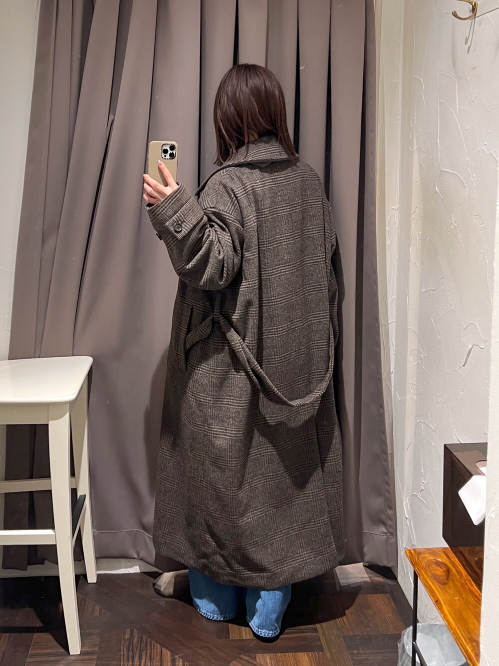 ブラウン系のステンカラーコート、ベージュ系のニット/セーター、ブラウン系のボストンバッグを着用したレディースの秋コーディネートの4枚目の写真