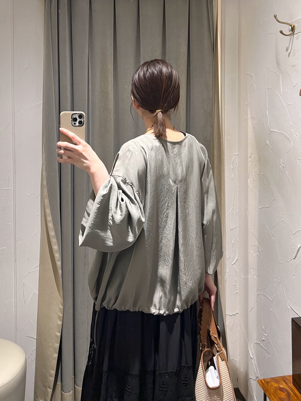 グリーン系のブルゾン、ブラック系のニット/セーター、ブラウン系のトートバッグを着用したレディースの夏コーディネートの5枚目の写真