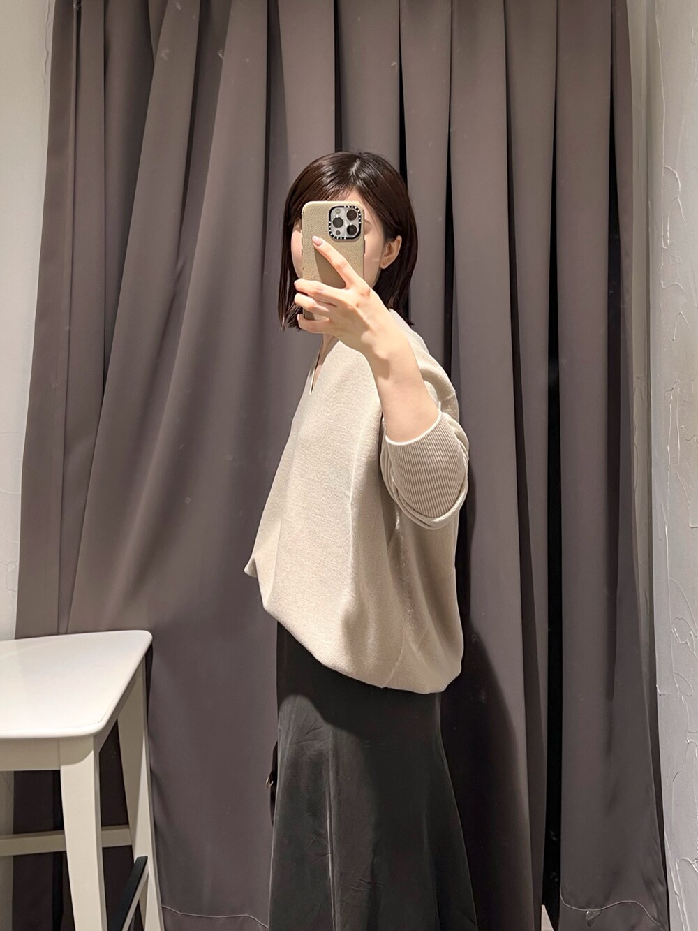 ベージュ系のニット/セーター、ブラウン系のスカート、ブラウン系のボストンバッグを着用したレディースの秋コーディネートの6枚目の写真