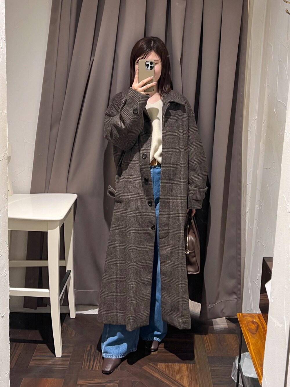 ブラウン系のステンカラーコート、ベージュ系のニット/セーター、ブラウン系のボストンバッグを着用したレディースの秋コーディネートの2枚目の写真