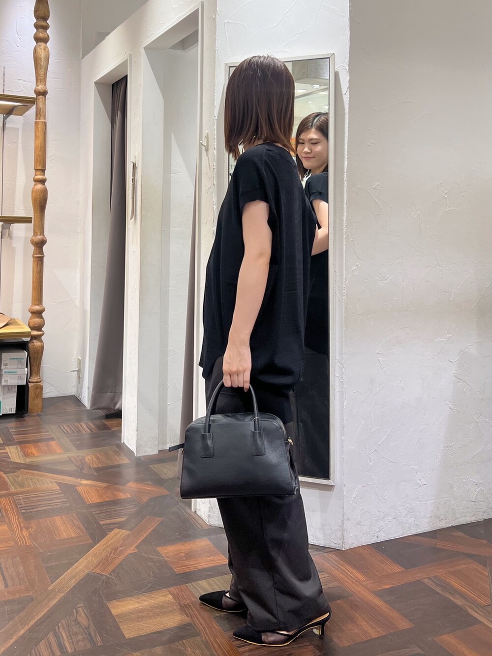 ブラック系のニット/セーター、ブラック系のボストンバッグ、ブラック系のパンプスを着用したレディースの秋コーディネートの3枚目の写真