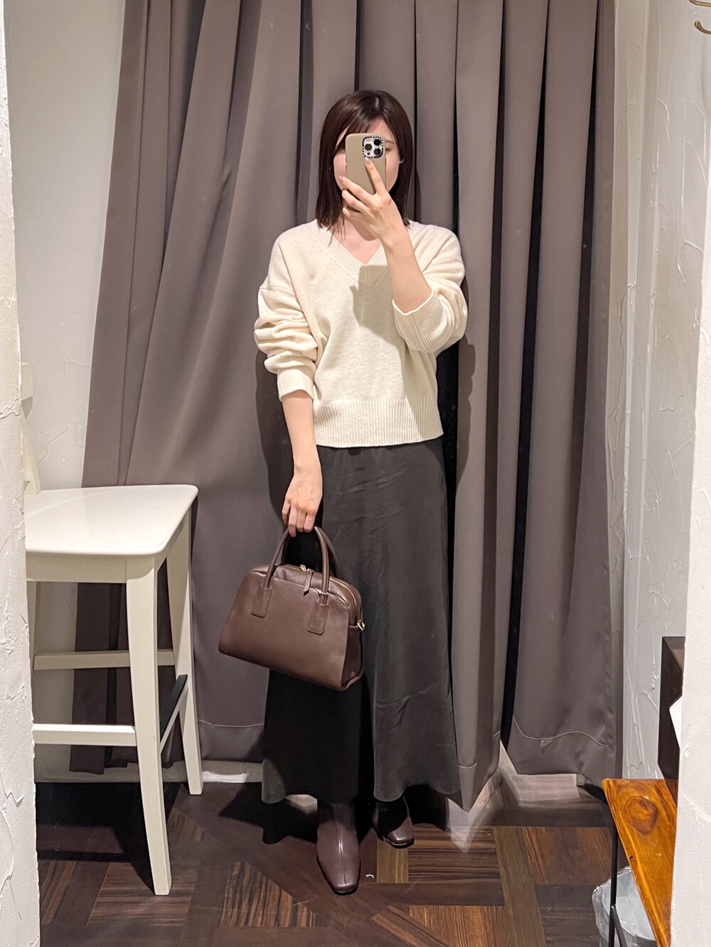 ホワイト系のニット/セーター、ブラウン系のボストンバッグ、ブラウン系のスカートを着用したレディースの秋コーディネートの2枚目の写真