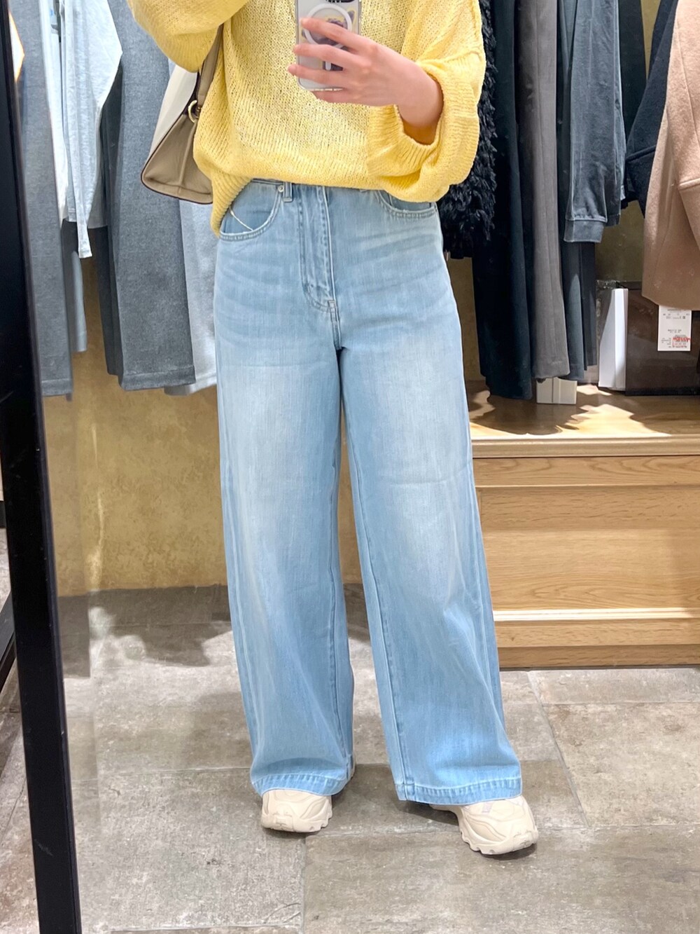 イエロー系のニット/セーター、ブルー系のデニムパンツを着用したレディースの冬コーディネートの6枚目の写真