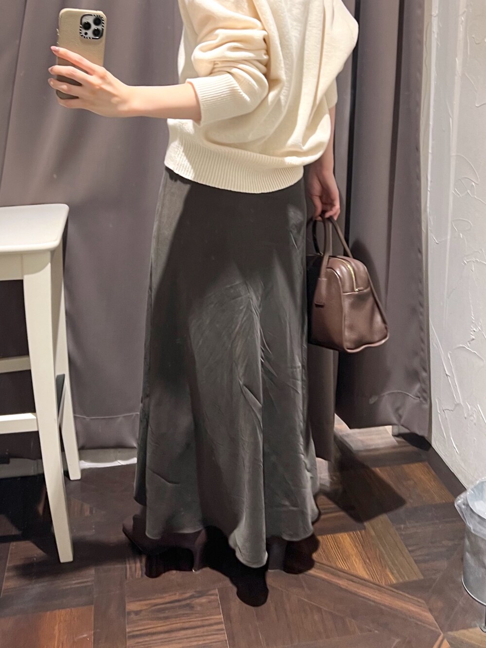 ホワイト系のニット/セーター、ブラウン系のボストンバッグ、ブラウン系のスカートを着用したレディースの秋コーディネートの10枚目の写真