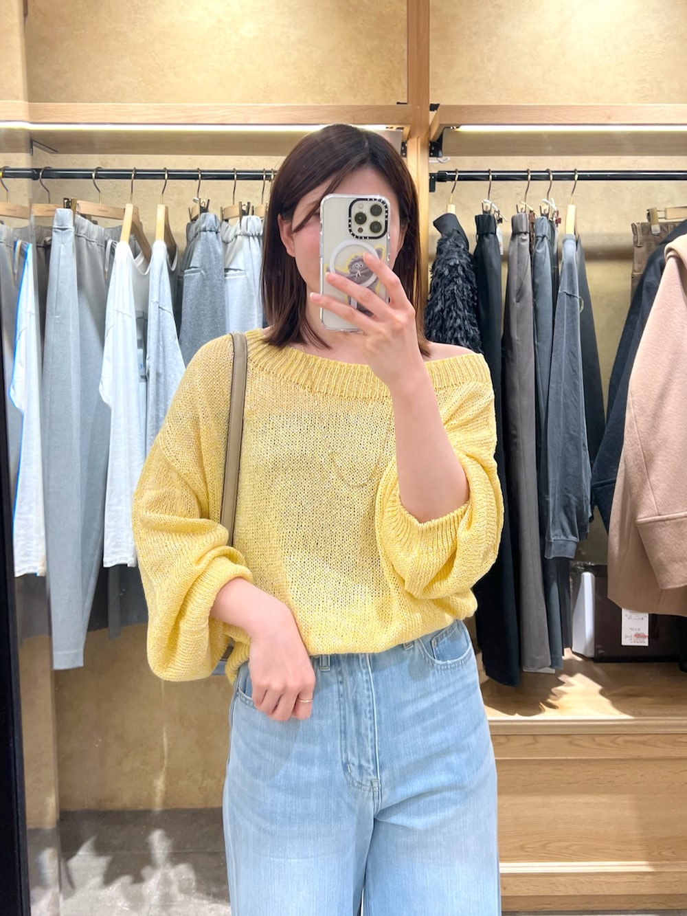 イエロー系のニット/セーター、ブルー系のデニムパンツを着用したレディースの冬コーディネートの3枚目の写真