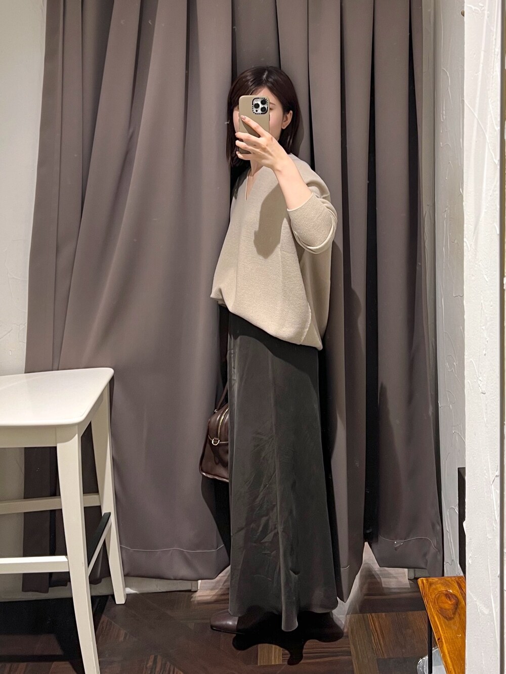 ベージュ系のニット/セーター、ブラウン系のスカート、ブラウン系のボストンバッグを着用したレディースの秋コーディネートの3枚目の写真