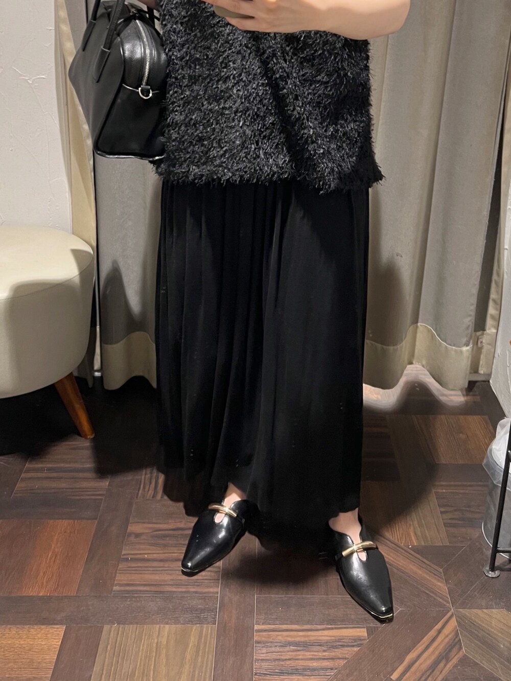 ブラック系のベスト、ブラック系のスカート、ブラック系のボストンバッグを着用したレディースの夏コーディネートの4枚目の写真