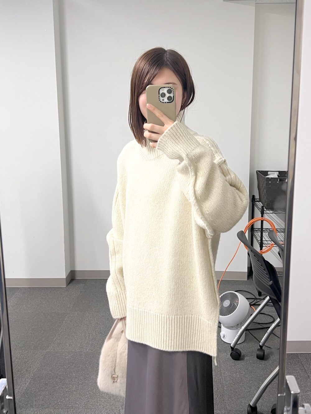 ベージュ系のボストンバッグ、ホワイト系のニット/セーター、ブラウン系のスカートを着用したレディースの秋コーディネートの5枚目の写真