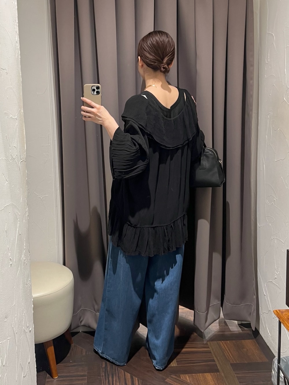 ブラック系のシャツ/ブラウス、ブルー系のデニムパンツ、ブラック系のパンプスを着用したレディースの冬コーディネートの4枚目の写真