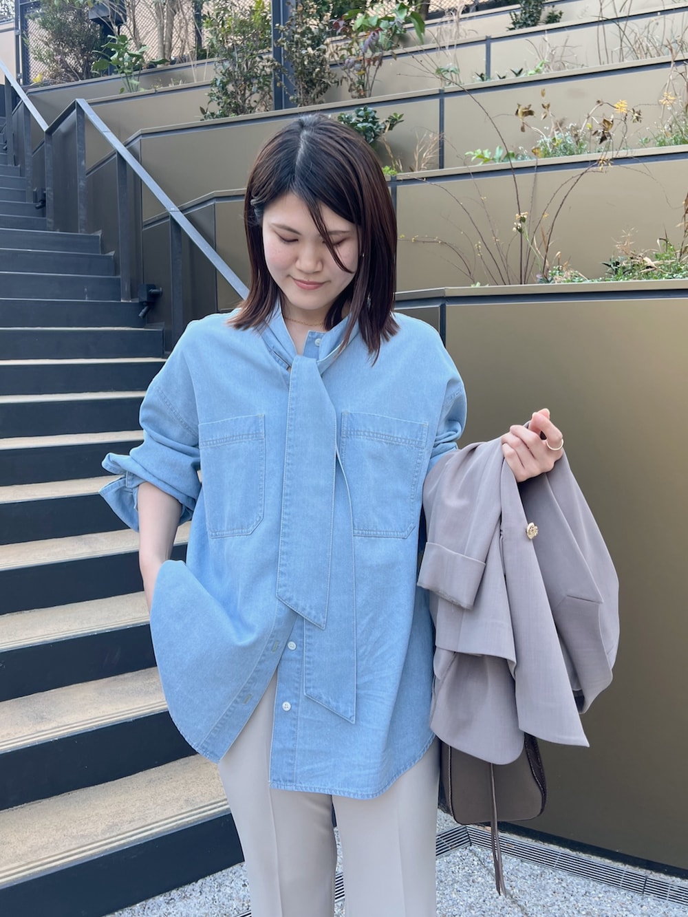 ブルー系のシャツ/ブラウス、ブラウン系のトートバッグ、ベージュ系のその他パンツを着用したレディースの冬コーディネートの3枚目の写真