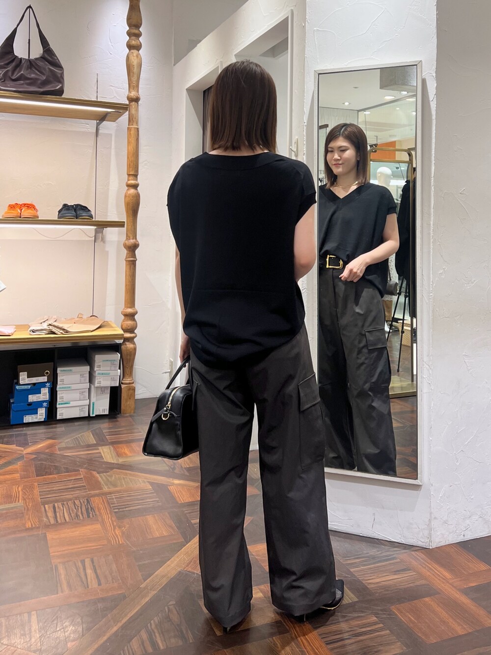 ブラック系のニット/セーター、ブラック系のボストンバッグ、ブラック系のパンプスを着用したレディースの秋コーディネートの4枚目の写真