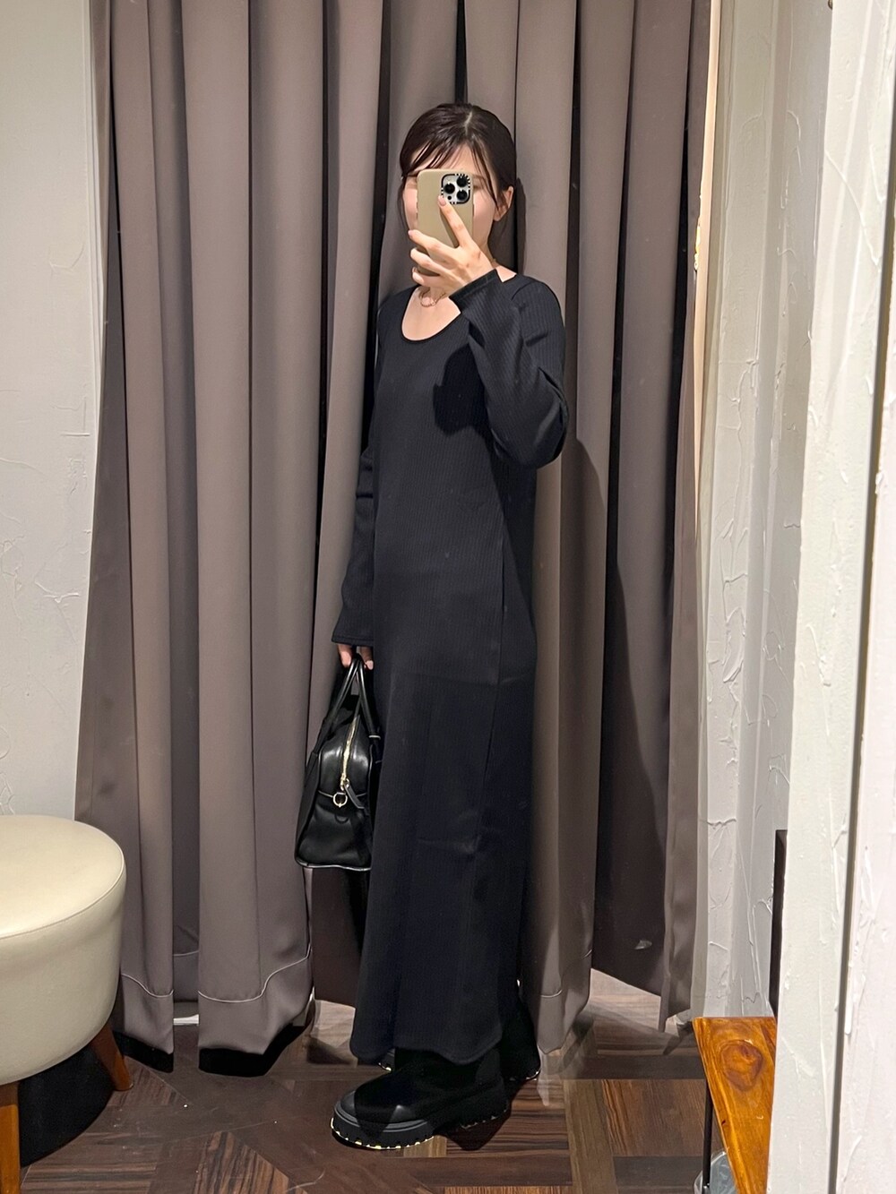 グレー系のその他アウター、ブラック系のワンピース、ブラック系のボストンバッグを着用したレディースの秋コーディネートの9枚目の写真