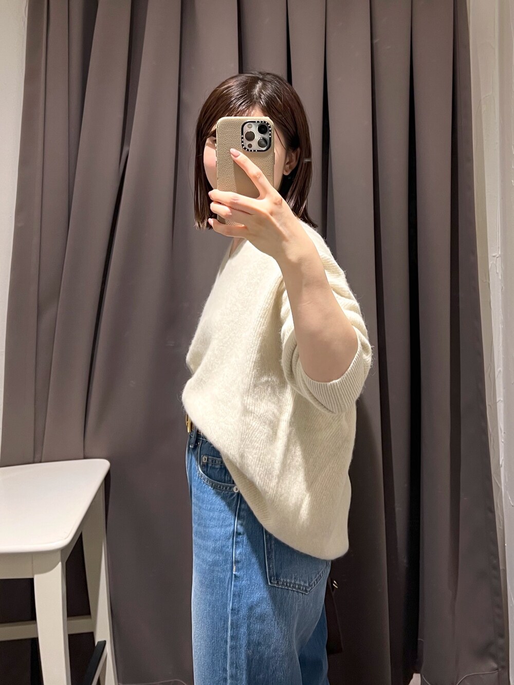 ベージュ系のニット/セーター、ブルー系のデニムパンツ、ブラウン系のボストンバッグを着用したレディースの秋コーディネートの6枚目の写真