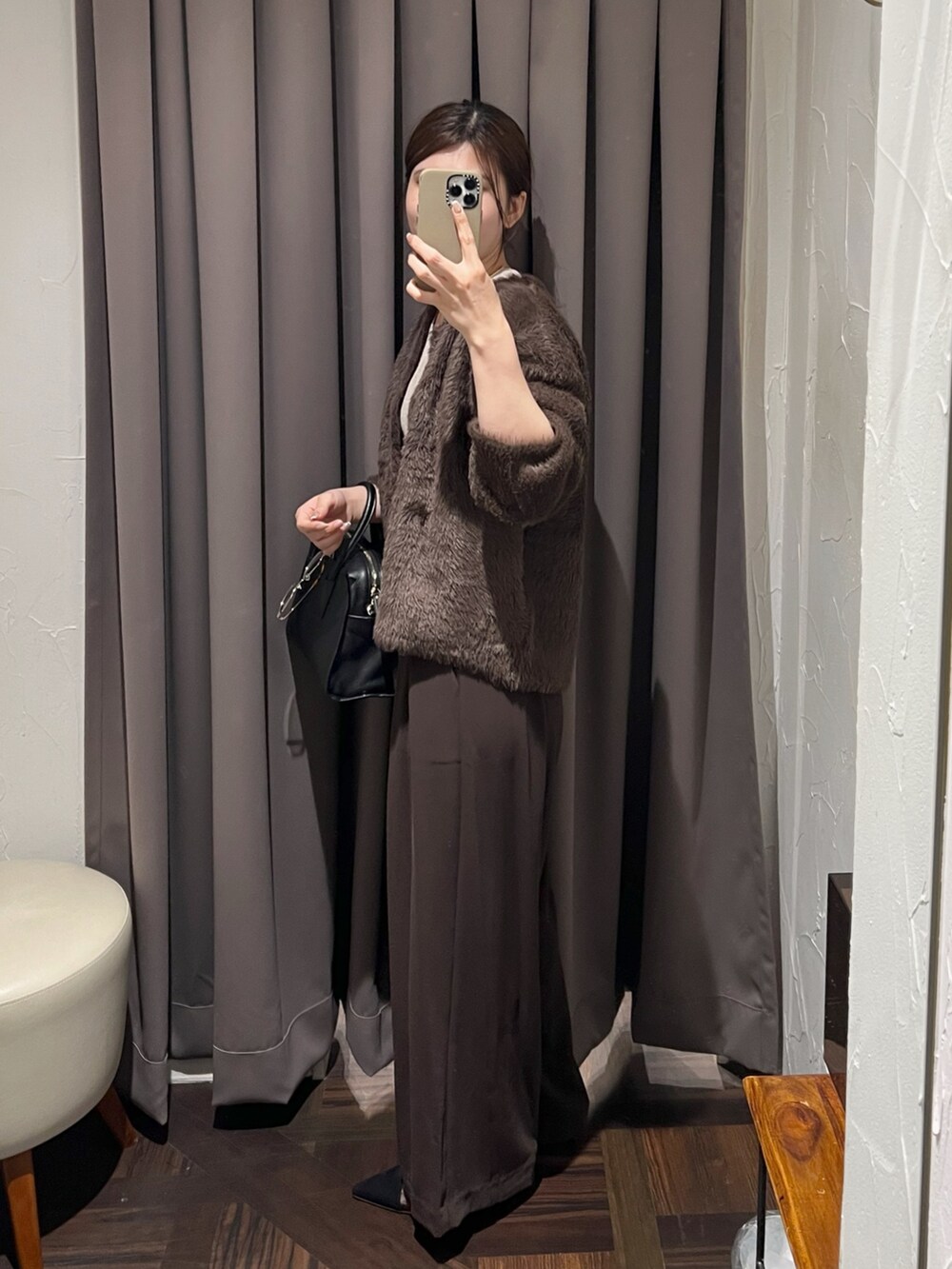 ブラウン系のカーディガン/ボレロ、ブラウン系のスラックス、ブラック系のパンプスを着用したレディースの冬コーディネートの3枚目の写真