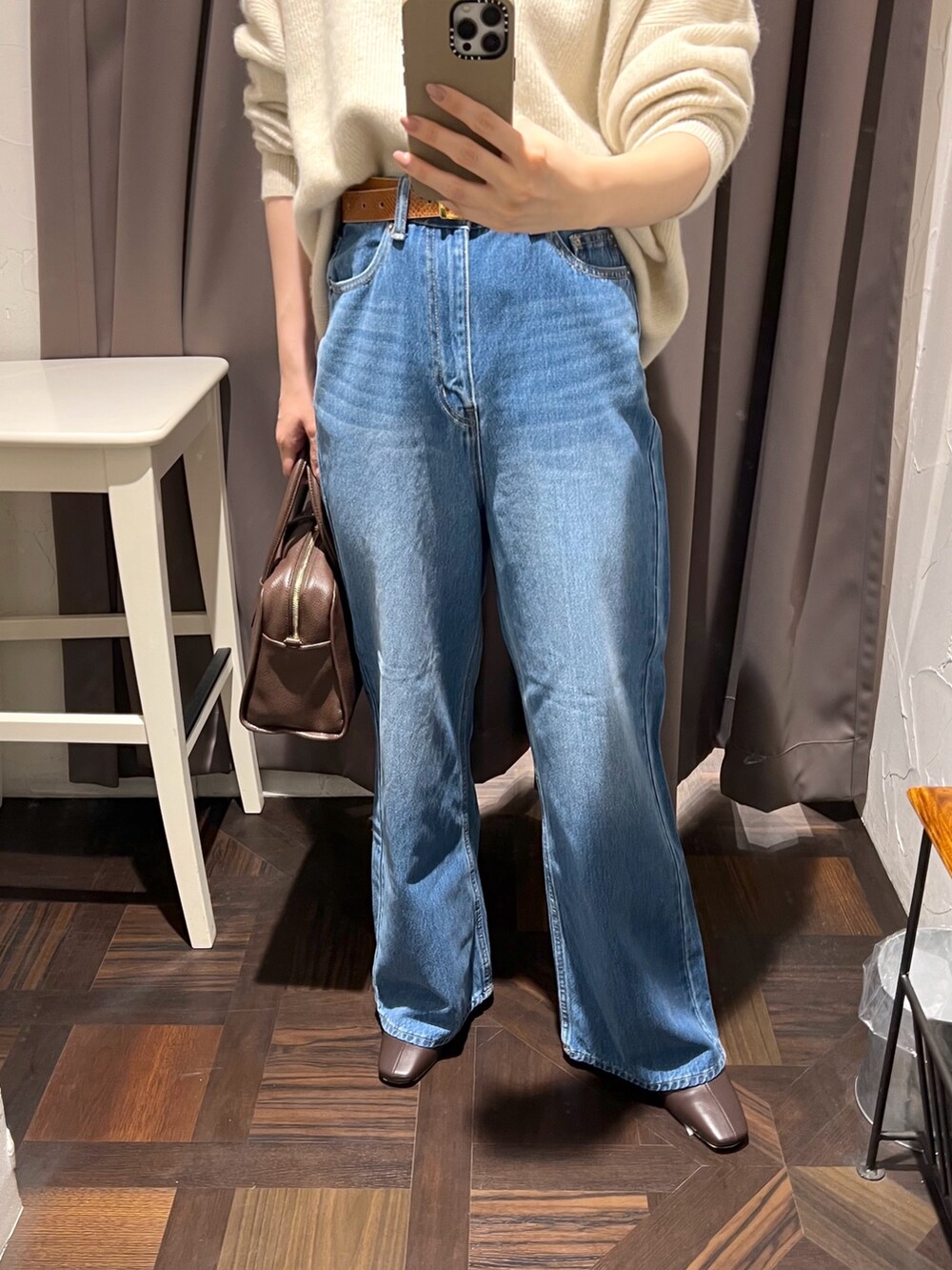 ブラウン系のステンカラーコート、ベージュ系のニット/セーター、ブラウン系のボストンバッグを着用したレディースの秋コーディネートの10枚目の写真