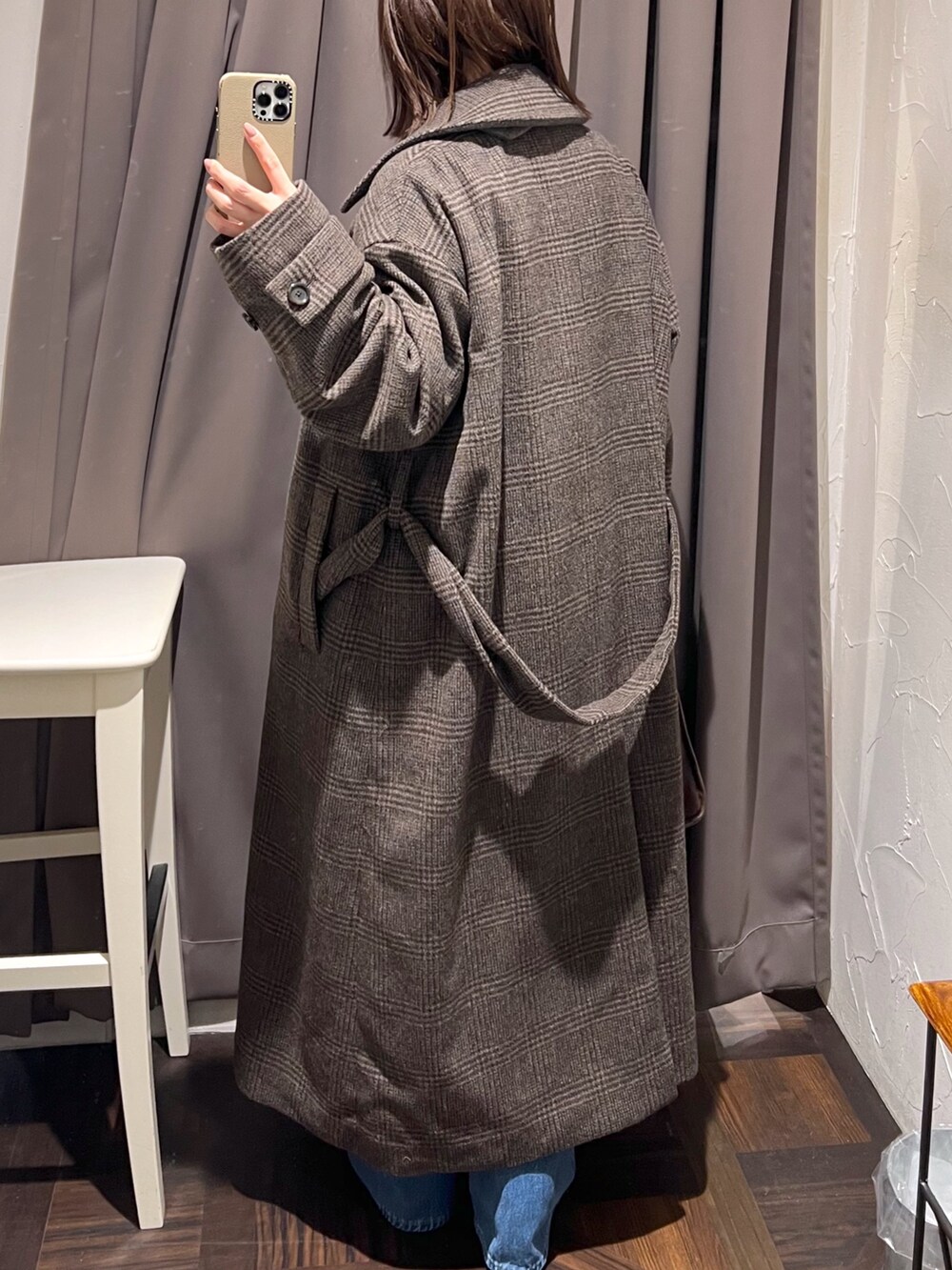 ブラウン系のステンカラーコート、ベージュ系のニット/セーター、ブラウン系のボストンバッグを着用したレディースの秋コーディネートの7枚目の写真