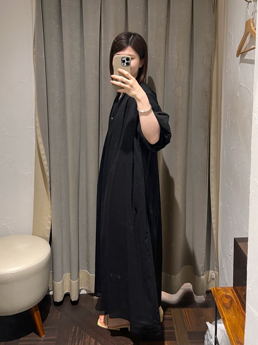 ブラック系のワンピース、ベージュ系のサンダル、ブラック系のハンドバッグを着用したレディースの夏コーディネートの2枚目の写真