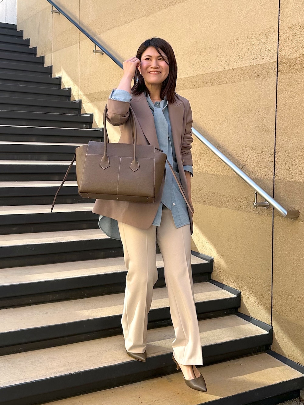 ブラウン系のテーラードジャケット、ブルー系のシャツ/ブラウス、ベージュ系のその他パンツを着用したレディースの冬コーディネートの2枚目の写真